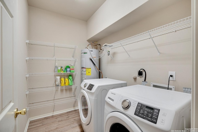 125 Wright Cv, Cibolo, TX 78108 - laundry area featuring washing machine and clothes dryer, light wood-style floors, electric water heater, and baseboards
