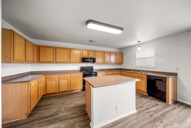 13214 Solar Crst, San Antonio, TX 78245 - kitchen with black appliances, dark wood-style floors, a sink, decorative light fixtures, and a kitchen island