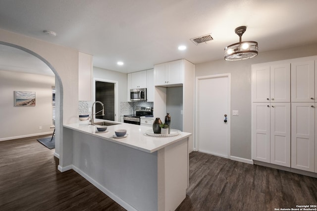 9723 Five Forks St, San Antonio, TX 78245 - kitchen featuring stainless steel appliances, a sink, arched walkways, white cabinets, and dark wood finished floors