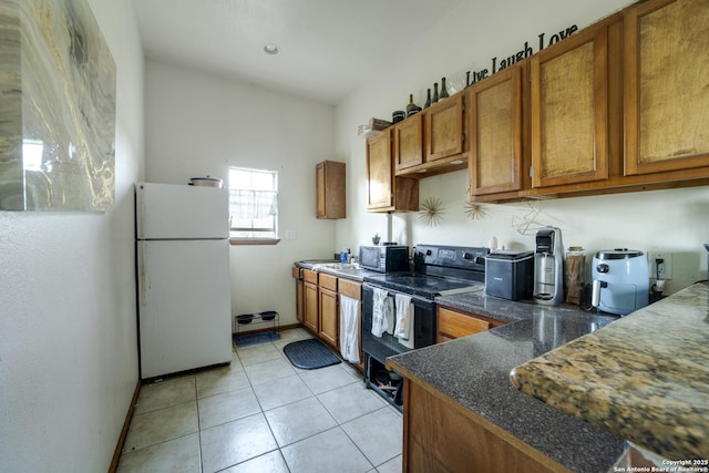 14053 Huber, Seguin, TX 78155 - kitchen featuring black appliances, brown cabinetry, light tile patterned floors, and baseboards