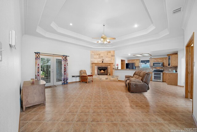 14053 Huber, Seguin, TX 78155 - living area with ceiling fan, a tray ceiling, a fireplace, light tile patterned floors, and ornamental molding
