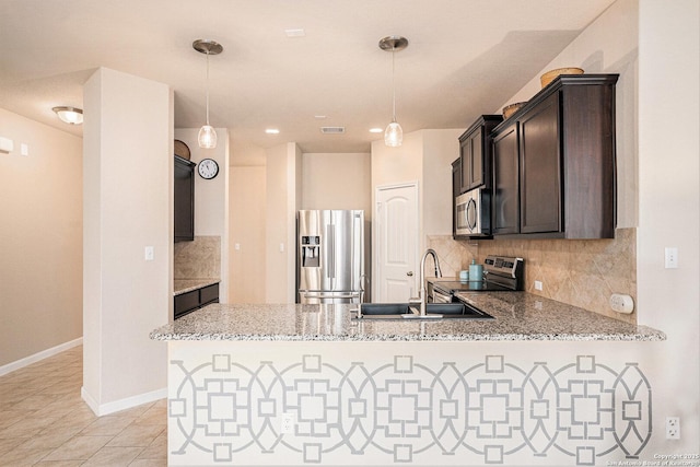 2196 New Castle, New Braunfels, TX 78130 - kitchen featuring stainless steel appliances, a sink, a peninsula, decorative backsplash, and light stone countertops