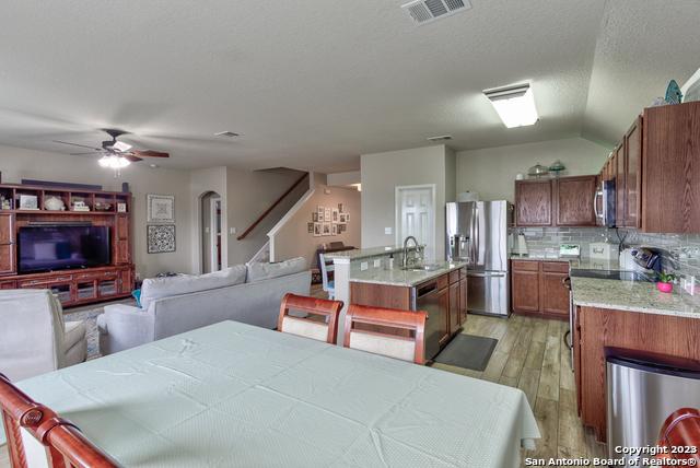 331 Primrose, New Braunfels, TX 78132 - dining room with a ceiling fan, stairs, light wood-style floors, lofted ceiling, and arched walkways