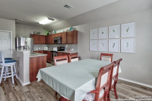 331 Primrose, New Braunfels, TX 78132 - dining room with light wood-style floors, lofted ceiling, and baseboards