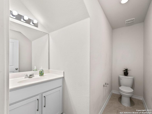 22146 Pivot Pt, San Antonio, TX 78261 - bathroom featuring vanity, toilet, tile patterned floors, vaulted ceiling, and baseboards