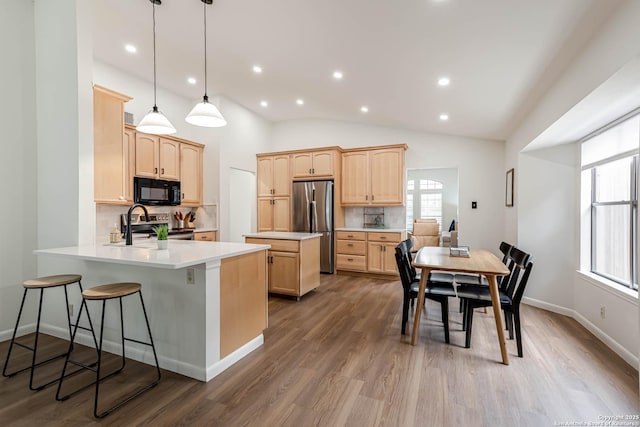 13755 Cedar Cyn, San Antonio, TX 78231 - kitchen featuring appliances with stainless steel finishes, light brown cabinets, decorative backsplash, a peninsula, and a sink