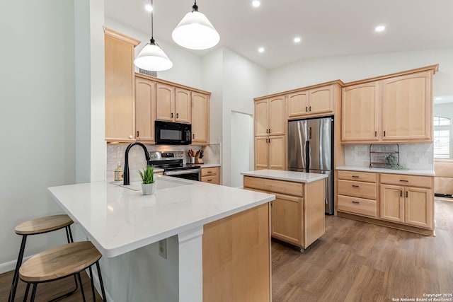 13755 Cedar Cyn, San Antonio, TX 78231 - kitchen featuring stainless steel appliances, light brown cabinets, a peninsula, a sink, and wood finished floors