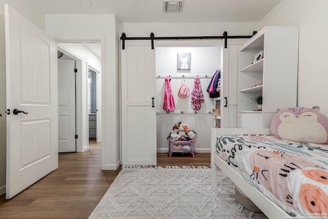 13755 Cedar Cyn, San Antonio, TX 78231 - bedroom with wood finished floors, a barn door, and baseboards