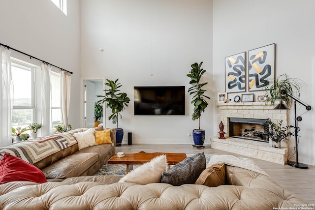 17703 San Felipe Bay, San Antonio, TX 78255 - living room featuring a high ceiling, healthy amount of natural light, wood finished floors, a stone fireplace, and baseboards