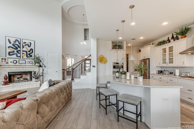 17703 San Felipe Bay, San Antonio, TX 78255 - kitchen with open floor plan, appliances with stainless steel finishes, a breakfast bar area, light countertops, and glass insert cabinets