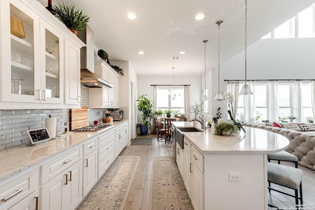 17703 San Felipe Bay, San Antonio, TX 78255 - kitchen with a sink, recessed lighting, wall chimney range hood, backsplash, and glass insert cabinets