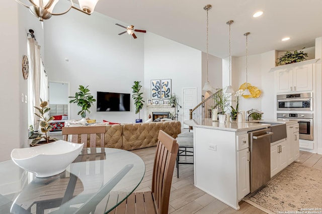 17703 San Felipe Bay, San Antonio, TX 78255 - kitchen with stainless steel appliances, open floor plan, a kitchen island with sink, light wood-style flooring, and a towering ceiling