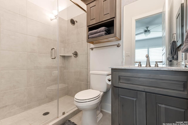 17703 San Felipe Bay, San Antonio, TX 78255 - bathroom with toilet, a stall shower, vanity, tile patterned floors, and a ceiling fan