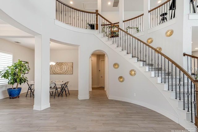 17703 San Felipe Bay, San Antonio, TX 78255 - stairs with wood finished floors, arched walkways, a towering ceiling, baseboards, and recessed lighting