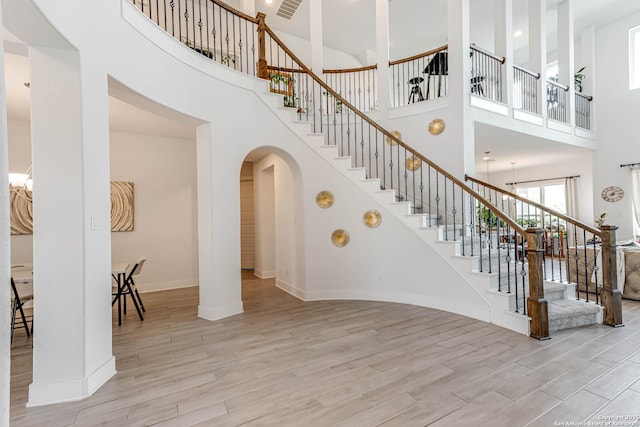 17703 San Felipe Bay, San Antonio, TX 78255 - stairs featuring arched walkways, a high ceiling, wood finished floors, and baseboards
