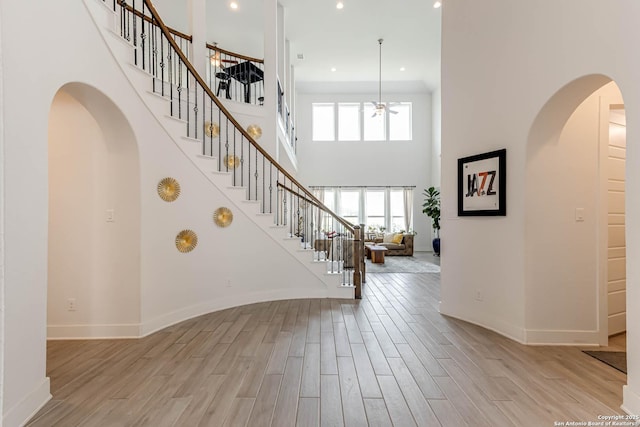17703 San Felipe Bay, San Antonio, TX 78255 - foyer featuring stairway, a towering ceiling, light wood finished floors, baseboards, and recessed lighting
