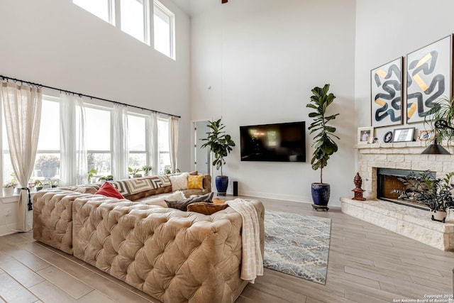 17703 San Felipe Bay, San Antonio, TX 78255 - living area with a high ceiling, wood finished floors, a stone fireplace, and baseboards