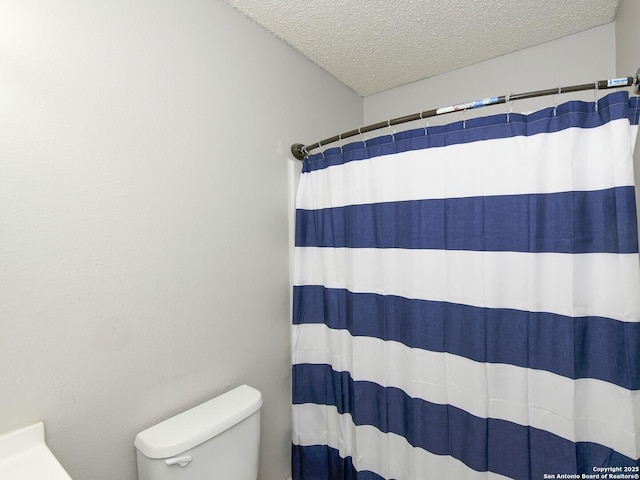 9730 Ivy Plain Dr, San Antonio, TX 78245 - bathroom featuring toilet, a textured ceiling, and curtained shower