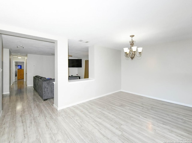 9730 Ivy Plain Dr, San Antonio, TX 78245 - unfurnished room featuring light wood-type flooring, a chandelier, and baseboards