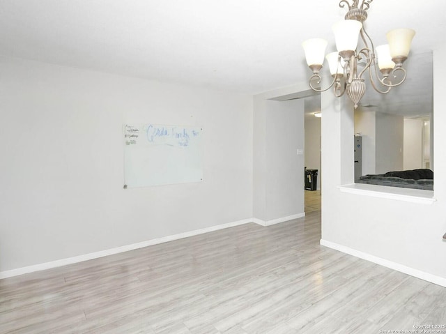 9730 Ivy Plain Dr, San Antonio, TX 78245 - empty room featuring wood finished floors, a chandelier, and baseboards