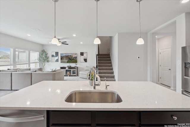 14607 Flatiron Clf, San Antonio, TX 78253 - kitchen with a sink, open floor plan, an island with sink, light stone counters, and hanging light fixtures