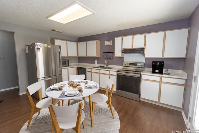 13043 Woller Crk, San Antonio, TX 78249 - kitchen with stainless steel appliances, under cabinet range hood, a sink, dark wood finished floors, and a textured ceiling