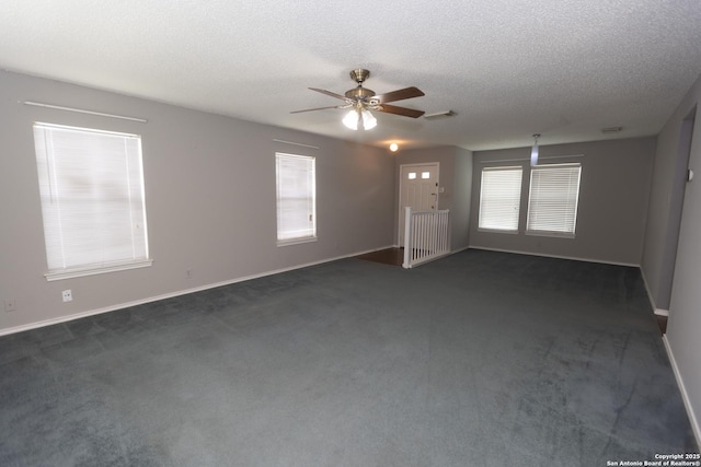 13043 Woller Crk, San Antonio, TX 78249 - unfurnished room featuring a ceiling fan, healthy amount of natural light, dark colored carpet, a textured ceiling, and baseboards