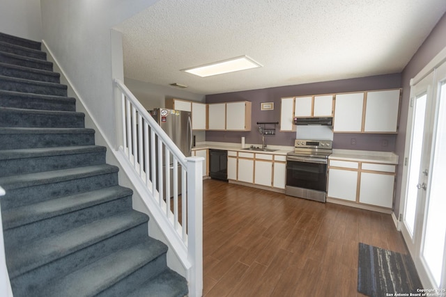 13043 Woller Crk, San Antonio, TX 78249 - kitchen featuring stainless steel appliances, under cabinet range hood, light countertops, dark wood-style flooring, and a textured ceiling