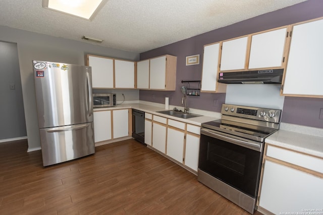 13043 Woller Crk, San Antonio, TX 78249 - kitchen with under cabinet range hood, appliances with stainless steel finishes, a sink, light countertops, and dark wood-style floors