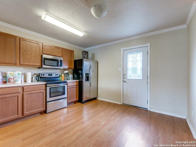 4622 Stallion Cv, San Antonio, TX 78244 - kitchen featuring stainless steel appliances, light wood-style flooring, crown molding, brown cabinets, and baseboards