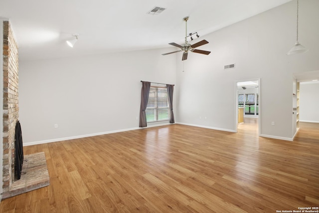 11519 Clifton Forge St, San Antonio, TX 78230 - unfurnished living room with ceiling fan, a brick fireplace, light wood-style floors, high vaulted ceiling, and baseboards