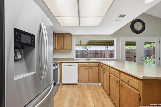 11519 Clifton Forge St, San Antonio, TX 78230 - kitchen with stainless steel appliances, a sink, a peninsula, light wood-style flooring, and light countertops