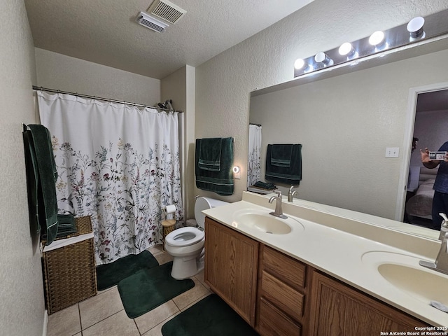 10518 Staggering, San Antonio, TX 78254 - bathroom featuring tile patterned floors, a textured wall, double vanity, toilet, and a textured ceiling