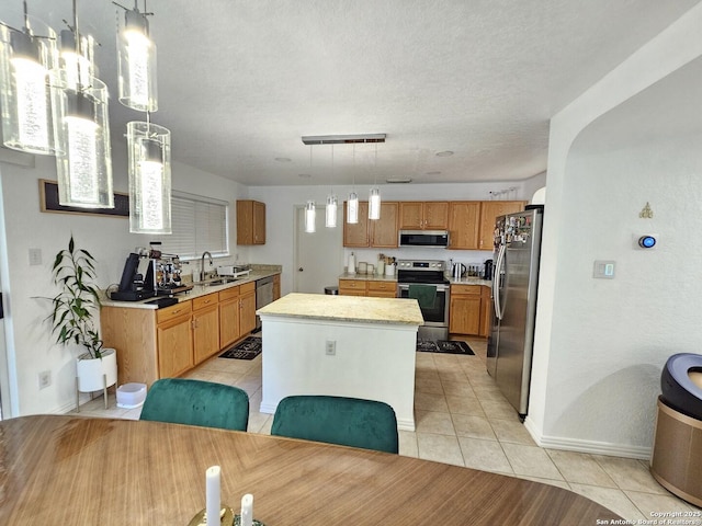10518 Staggering, San Antonio, TX 78254 - kitchen with appliances with stainless steel finishes, a sink, light countertops, light tile patterned flooring, and a kitchen island