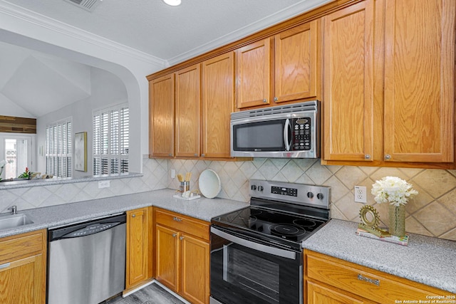10907 Sangria Mist, San Antonio, TX 78249 - kitchen featuring stainless steel appliances, plenty of natural light, backsplash, arched walkways, and crown molding