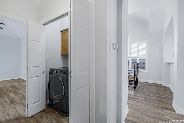 10907 Sangria Mist, San Antonio, TX 78249 - laundry area with cabinet space, washer / dryer, dark wood-style flooring, and arched walkways