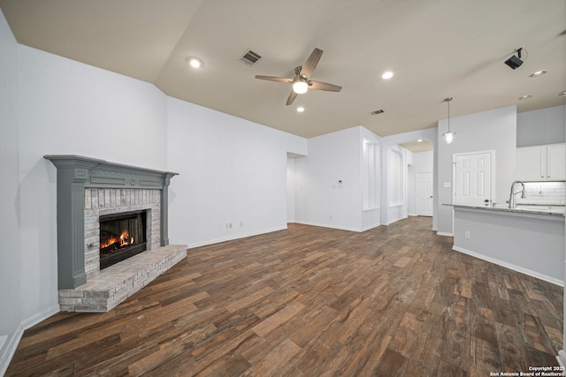 3615 Mill Mdw, San Antonio, TX 78247 - unfurnished living room with a ceiling fan, dark wood-style floors, a fireplace, a sink, and recessed lighting