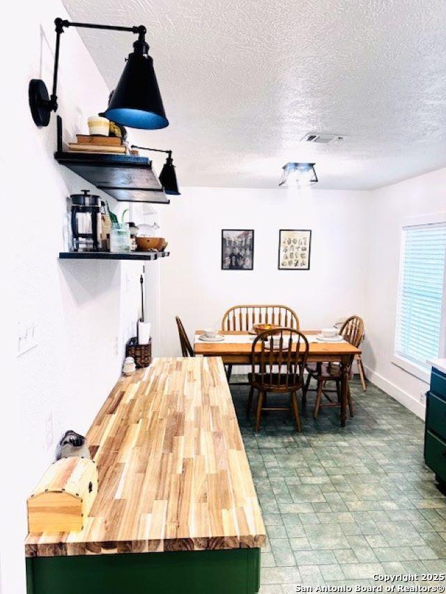 703 Mcdougal, San Antonio, TX 78223 - dining space featuring a textured ceiling and baseboards