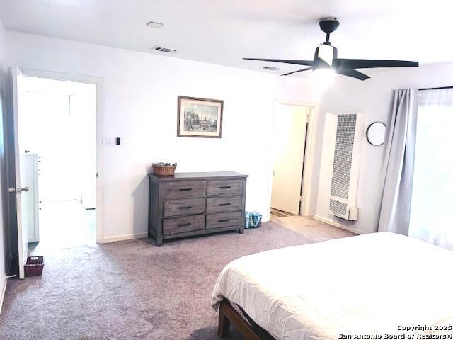 703 Mcdougal, San Antonio, TX 78223 - bedroom featuring a heating unit, light carpet, a ceiling fan, and baseboards
