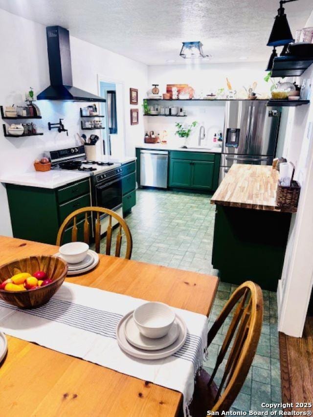 703 Mcdougal, San Antonio, TX 78223 - kitchen with green cabinetry, open shelves, wall chimney range hood, appliances with stainless steel finishes, and a sink