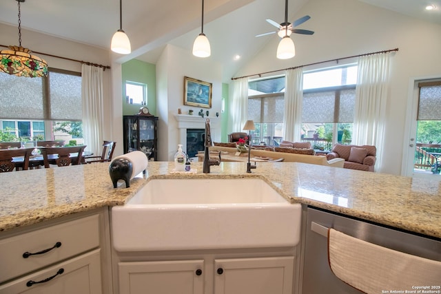 4634 Makayla Cross, San Antonio, TX 78261 - kitchen featuring stainless steel dishwasher, open floor plan, a sink, a glass covered fireplace, and vaulted ceiling