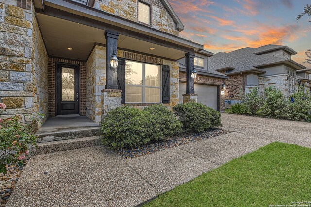 32241 Tamarind, Bulverde, TX 78163 - exterior entry at dusk with stone siding and driveway