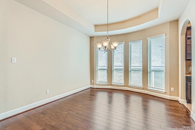32241 Tamarind, Bulverde, TX 78163 - spare room with a chandelier, a raised ceiling, dark wood finished floors, and baseboards