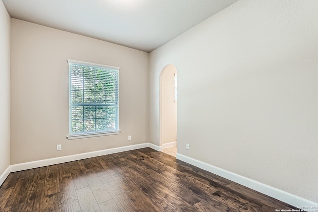 32241 Tamarind, Bulverde, TX 78163 - empty room featuring arched walkways, dark wood finished floors, and baseboards