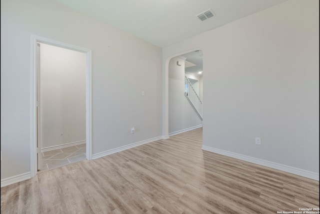 5245 Nature Path, Schertz, TX 78154 - empty room featuring light wood-style flooring, arched walkways, baseboards, and stairway