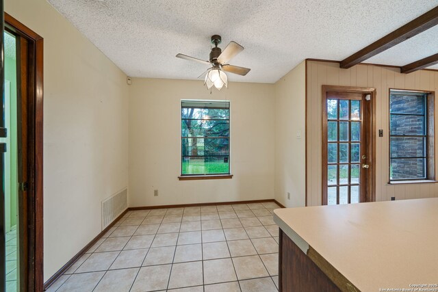 2822 Low Oak, San Antonio, TX 78232 - unfurnished dining area featuring plenty of natural light, a ceiling fan, a textured ceiling, light tile patterned floors, and beam ceiling
