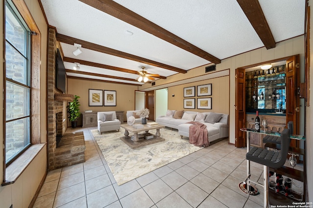 2822 Low Oak, San Antonio, TX 78232 - living area with beamed ceiling, light tile patterned flooring, a textured ceiling, ceiling fan, and a fireplace
