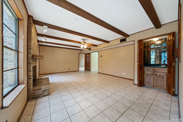 2822 Low Oak, San Antonio, TX 78232 - unfurnished living room featuring beam ceiling, a ceiling fan, a textured ceiling, wooden walls, and light tile patterned floors