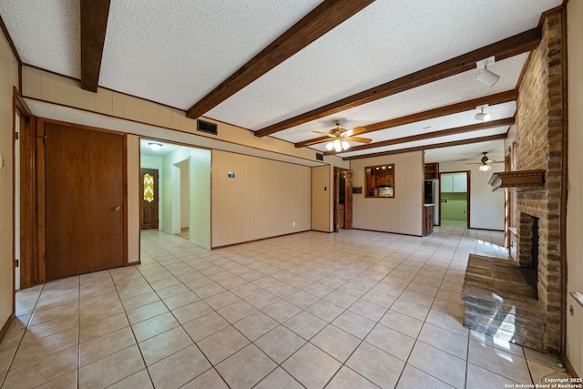 2822 Low Oak, San Antonio, TX 78232 - unfurnished living room featuring ceiling fan, a textured ceiling, light tile patterned floors, a fireplace, and beamed ceiling