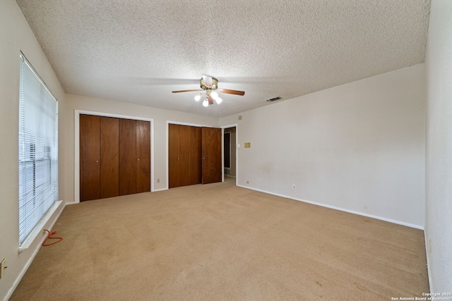 2822 Low Oak, San Antonio, TX 78232 - unfurnished bedroom featuring carpet, multiple closets, baseboards, a textured ceiling, and ceiling fan